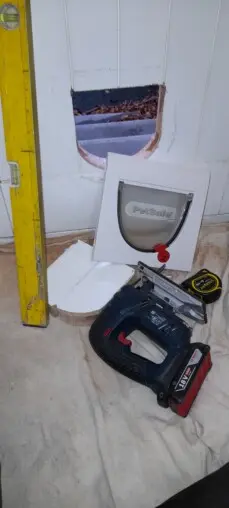 Cat flap fitted into wood doors. White cat flap.